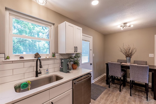 5518 Cyanamid Rd, Milton, FL 32583 - kitchen with a sink, dishwasher, light wood-style floors, decorative backsplash, and light countertops
