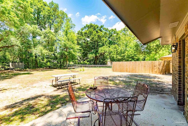5518 Cyanamid Rd, Milton, FL 32583 - view of patio / terrace featuring fence, outdoor dining area, and view of wooded area
