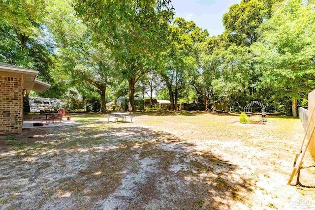 5518 Cyanamid Rd, Milton, FL 32583 - fenced backyard with view of wooded area and a patio area