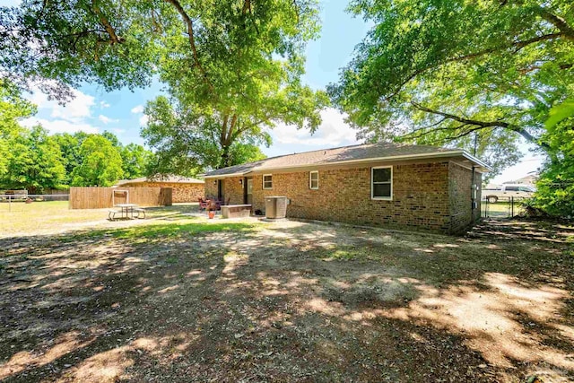 5518 Cyanamid Rd, Milton, FL 32583 - back of property featuring central AC unit, a patio area, brick siding, and fence
