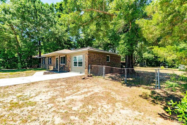 5518 Cyanamid Rd, Milton, FL 32583 - view of front of house with fence, brick siding, a gate, and view of scattered trees