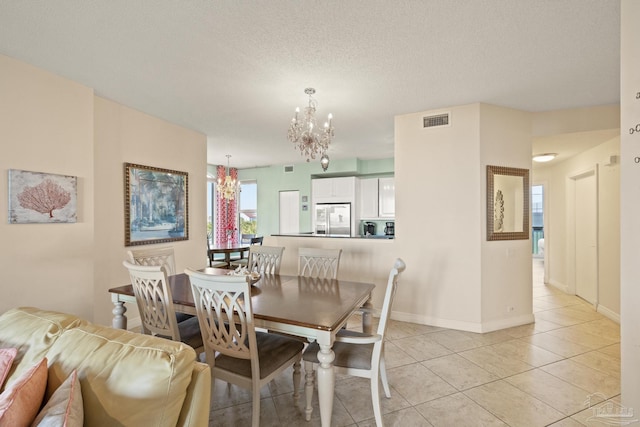 tiled dining area with a textured ceiling and a chandelier