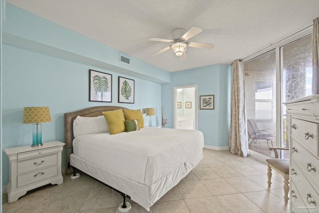 bedroom featuring light tile patterned floors, connected bathroom, a textured ceiling, and ceiling fan