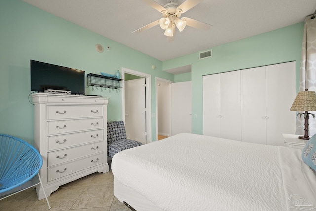 bedroom with ceiling fan, a closet, and light tile patterned floors