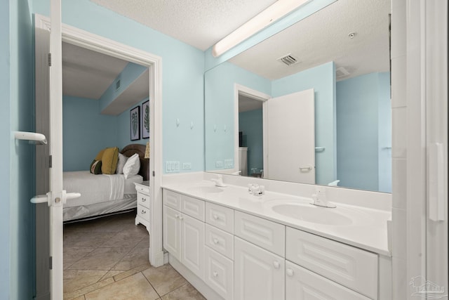 bathroom featuring tile patterned flooring, vanity, and a textured ceiling