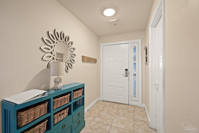 tiled entrance foyer featuring a textured ceiling