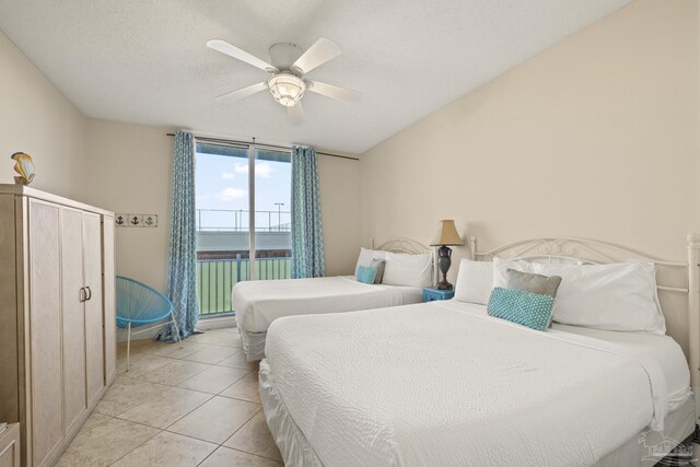 bedroom featuring ceiling fan, light tile patterned flooring, and a textured ceiling