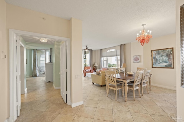 dining space featuring light tile patterned flooring, a chandelier, and a textured ceiling