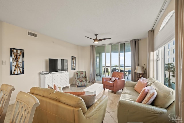 living room with light tile patterned floors, a textured ceiling, and ceiling fan