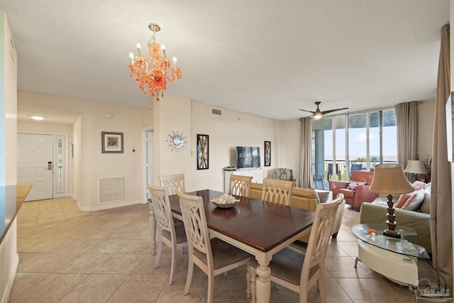 tiled dining area featuring ceiling fan with notable chandelier and a textured ceiling