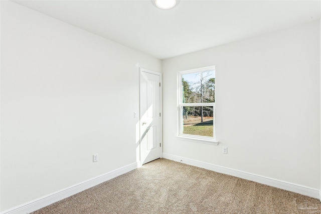 empty room featuring baseboards and light colored carpet