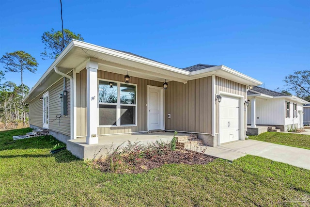 ranch-style home featuring a garage, covered porch, concrete driveway, and a front yard