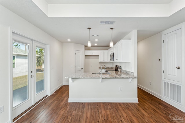 kitchen with visible vents, a peninsula, baseboards, and light stone countertops