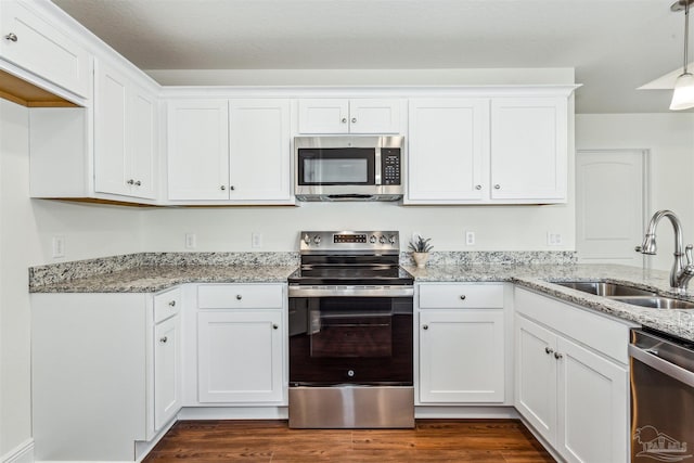 kitchen featuring stainless steel appliances, a sink, dark wood finished floors, and white cabinets