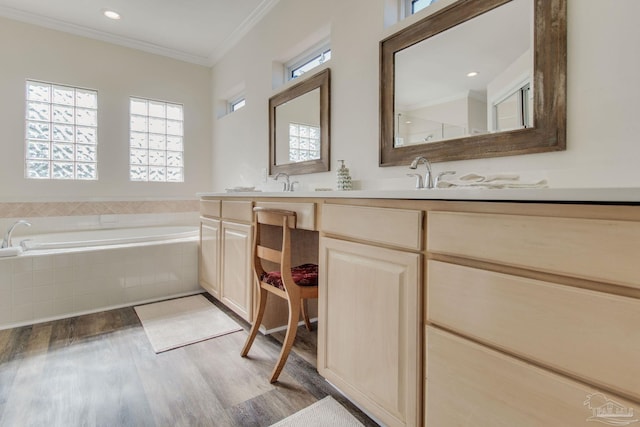 bathroom with vanity, tiled tub, wood-type flooring, and ornamental molding