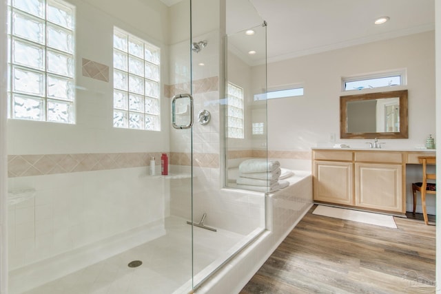 bathroom featuring ornamental molding, plus walk in shower, wood-type flooring, and vanity