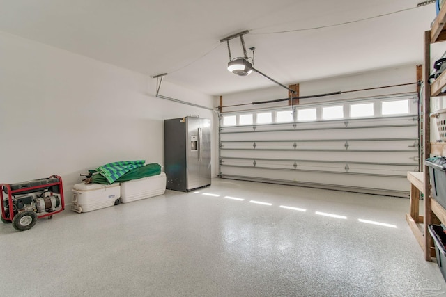 garage with stainless steel fridge with ice dispenser and a garage door opener