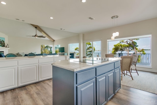 kitchen with gray cabinets, a kitchen island, pendant lighting, black electric stovetop, and white cabinets