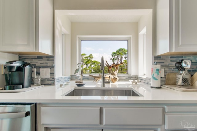 kitchen featuring white cabinetry, dishwasher, sink, and tasteful backsplash