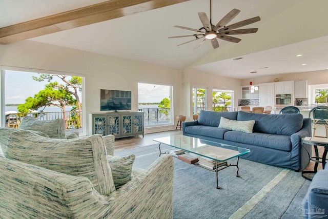 living room with ceiling fan, light hardwood / wood-style floors, and vaulted ceiling