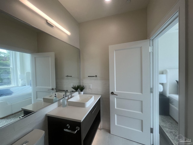 bathroom featuring tile patterned flooring, vanity, and tile walls