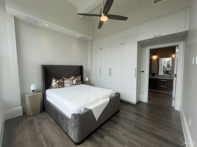 bedroom with a closet, baseboards, and dark wood-type flooring