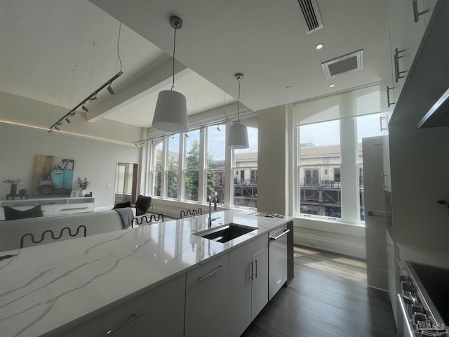 kitchen with light stone counters, visible vents, stainless steel dishwasher, stove, and a sink