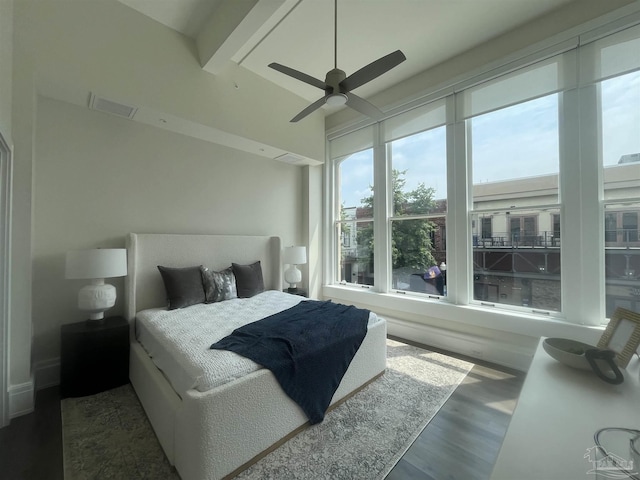 bedroom featuring ceiling fan, visible vents, wood finished floors, and beamed ceiling