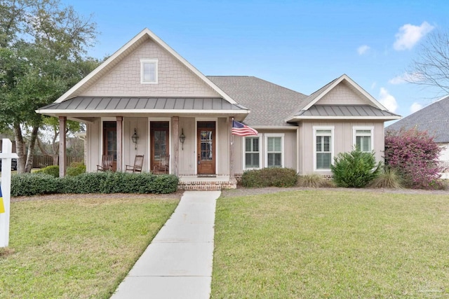 view of front of property with a porch, a shingled roof, board and batten siding, a standing seam roof, and a front lawn