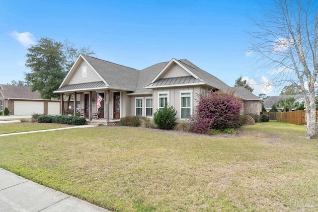 view of front facade with board and batten siding, a front yard, a standing seam roof, fence, and metal roof