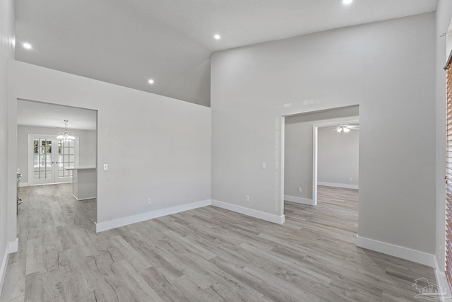 unfurnished room with light wood-type flooring, ceiling fan, and lofted ceiling