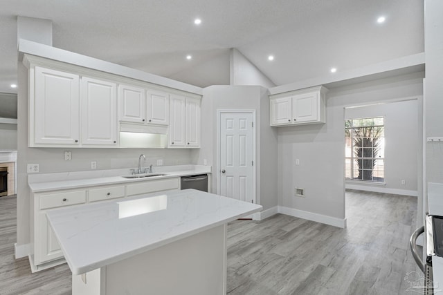 kitchen with dishwasher, a center island, sink, light stone countertops, and white cabinetry