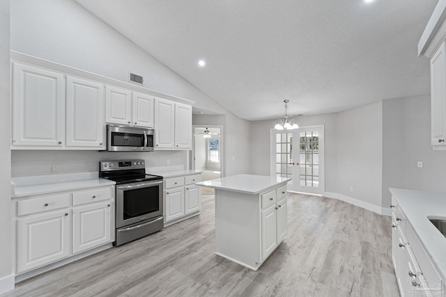 kitchen with white cabinetry, a kitchen island, hanging light fixtures, and appliances with stainless steel finishes