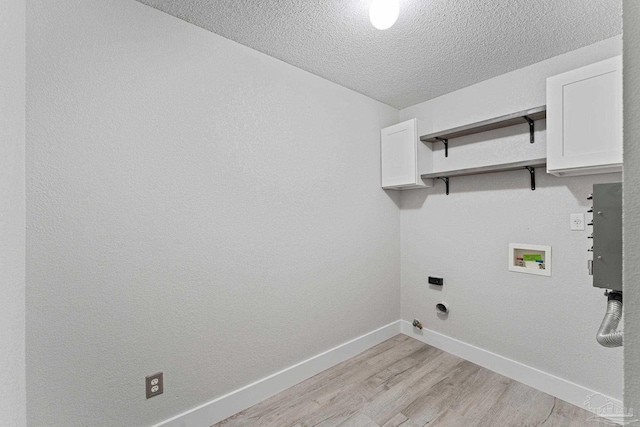 washroom featuring hookup for a washing machine, light wood-type flooring, a textured ceiling, and electric dryer hookup