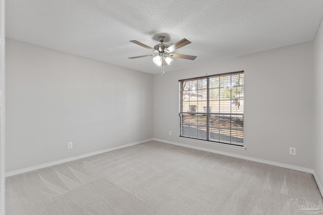 carpeted empty room featuring ceiling fan and a textured ceiling