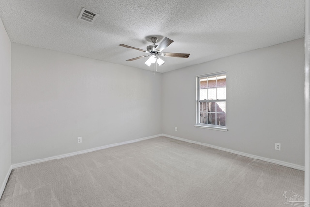 carpeted empty room featuring ceiling fan and a textured ceiling