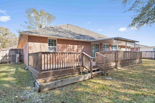 rear view of property with a lawn, a deck, and central air condition unit