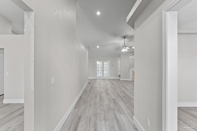 corridor with french doors and light wood-type flooring