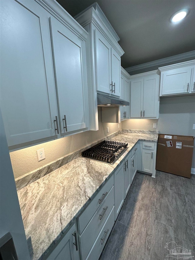 kitchen with light stone countertops, stainless steel gas cooktop, and white cabinetry