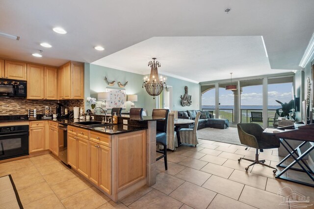 4 Portofino Dr Unit 803, Pensacola Beach, FL 32561 - kitchen featuring a sink, black appliances, a breakfast bar, tasteful backsplash, and light brown cabinets