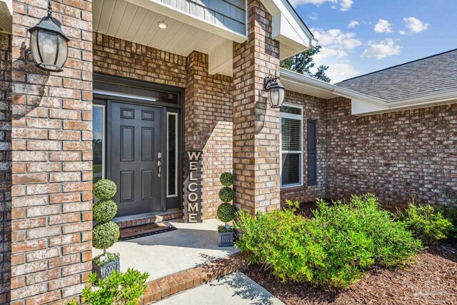 view of exterior entry featuring covered porch