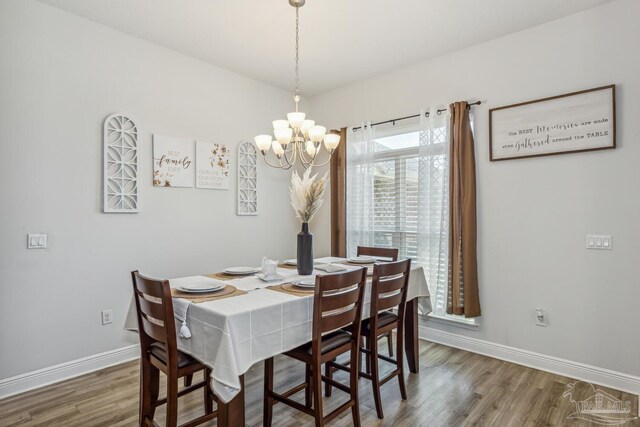 dining area with a notable chandelier and dark hardwood / wood-style floors