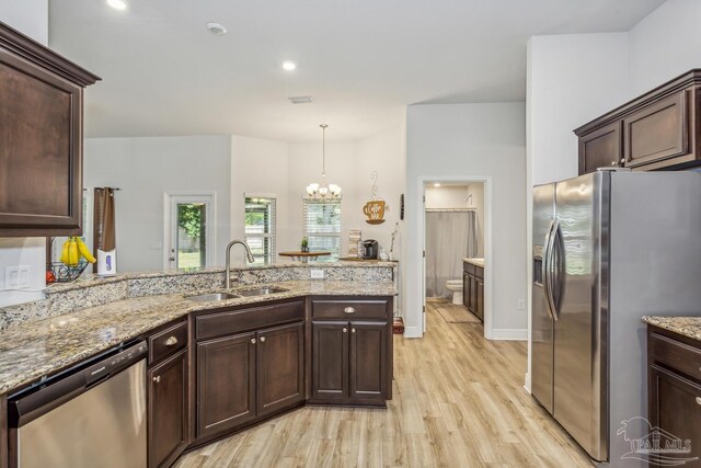 kitchen featuring appliances with stainless steel finishes, light hardwood / wood-style floors, an inviting chandelier, dark brown cabinetry, and sink