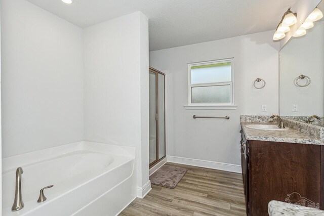 bathroom featuring vanity, shower with separate bathtub, and hardwood / wood-style floors