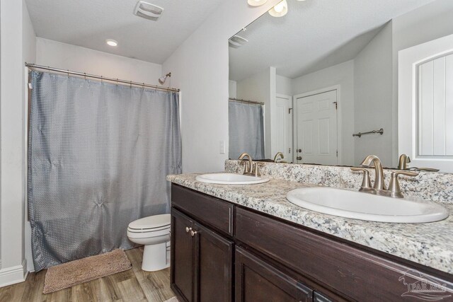 full bathroom featuring shower / tub combo, vanity, toilet, ceiling fan, and hardwood / wood-style floors