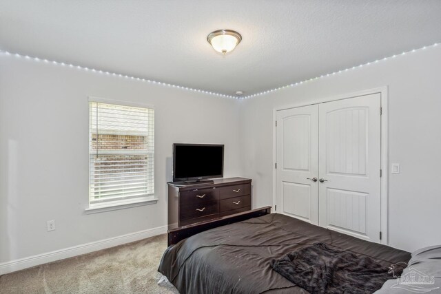 carpeted bedroom featuring a closet and a textured ceiling