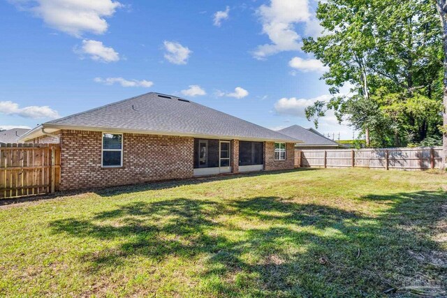 rear view of house featuring a yard