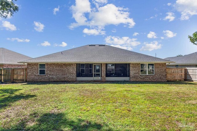 rear view of property with a yard