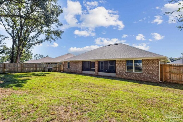 rear view of property with a yard