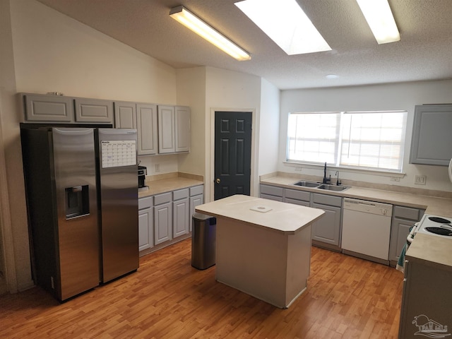 kitchen featuring stainless steel refrigerator with ice dispenser, sink, light hardwood / wood-style flooring, dishwasher, and a kitchen island